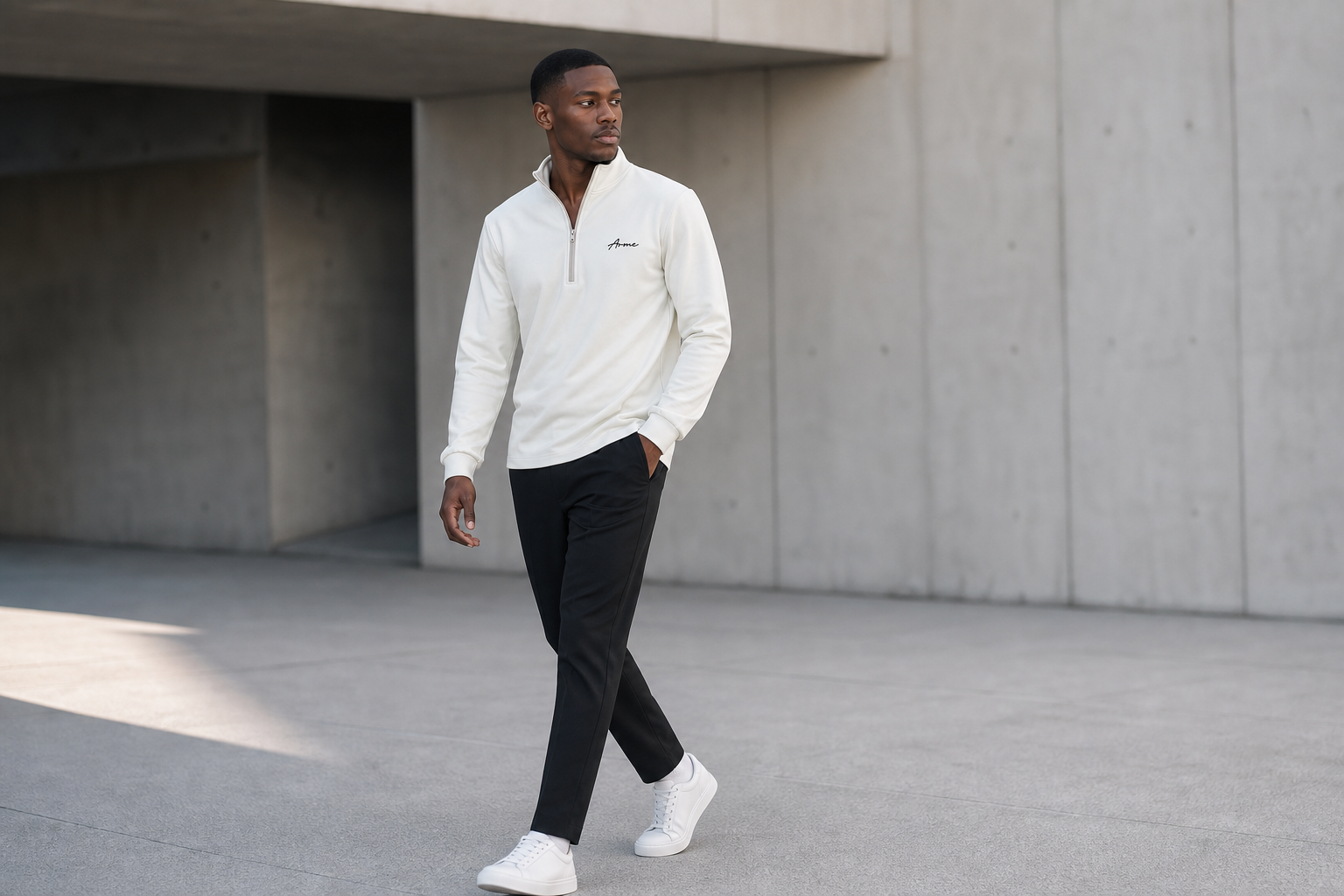 Model walking in the ARME cream quarter zip with black trousers