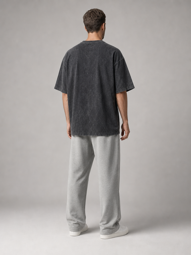 Model wearing the ARME oversized performance tee in washed charcoal, back view